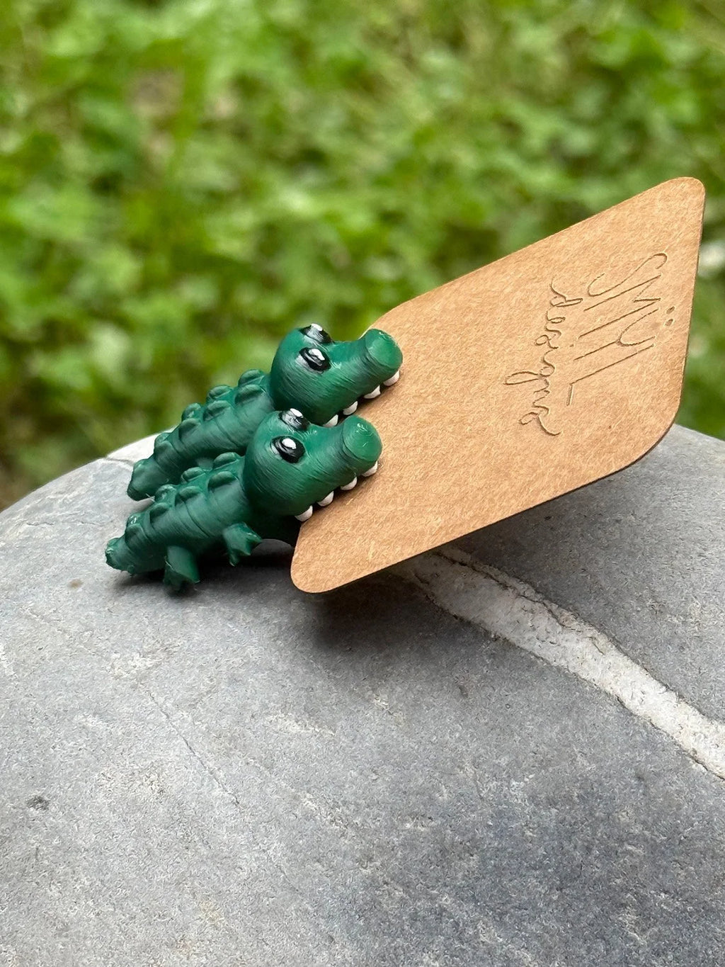 Side view of green chomping alligator earrings