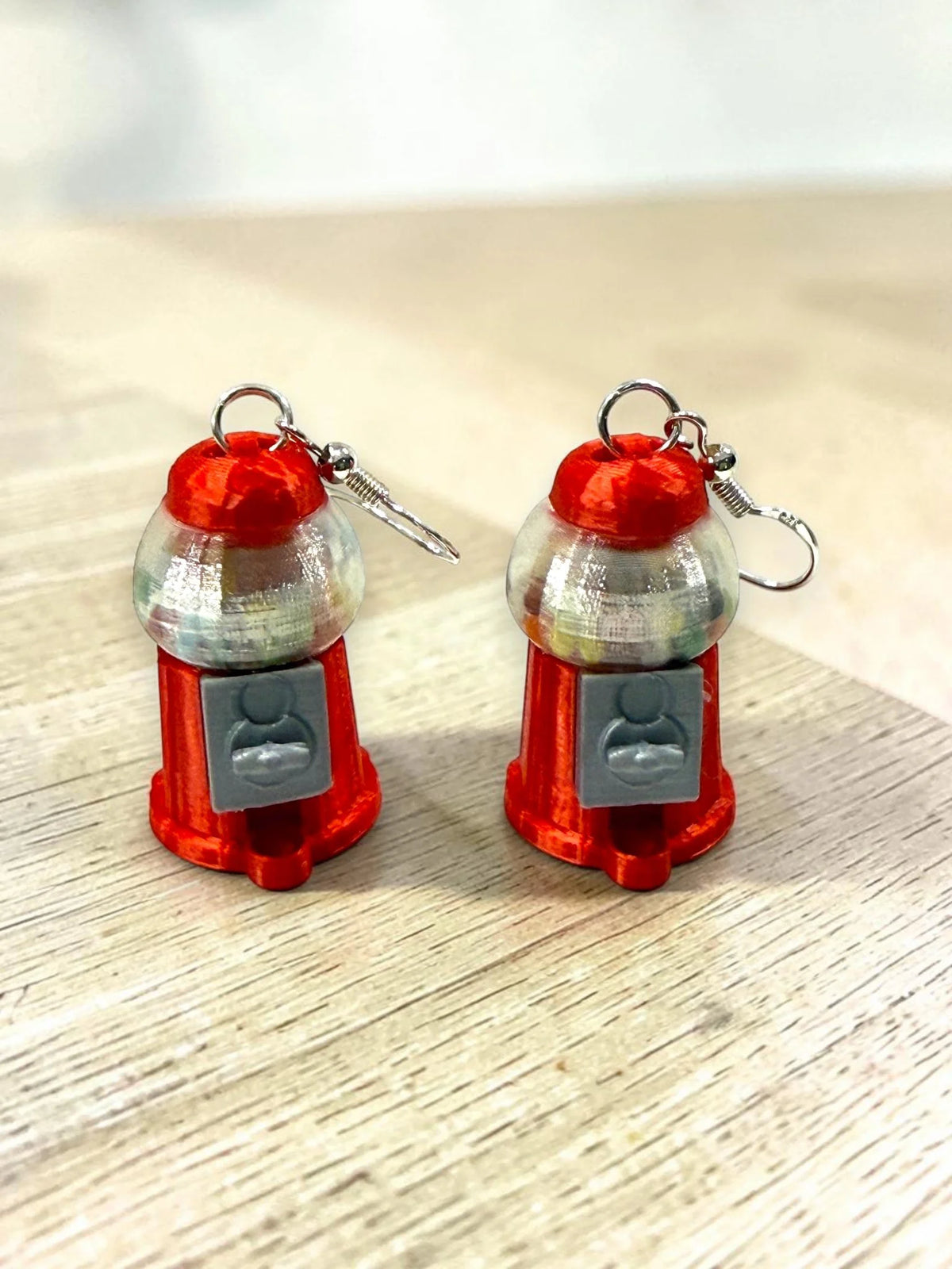 Red 3D-printed gumball machine earrings with shakeable beads
