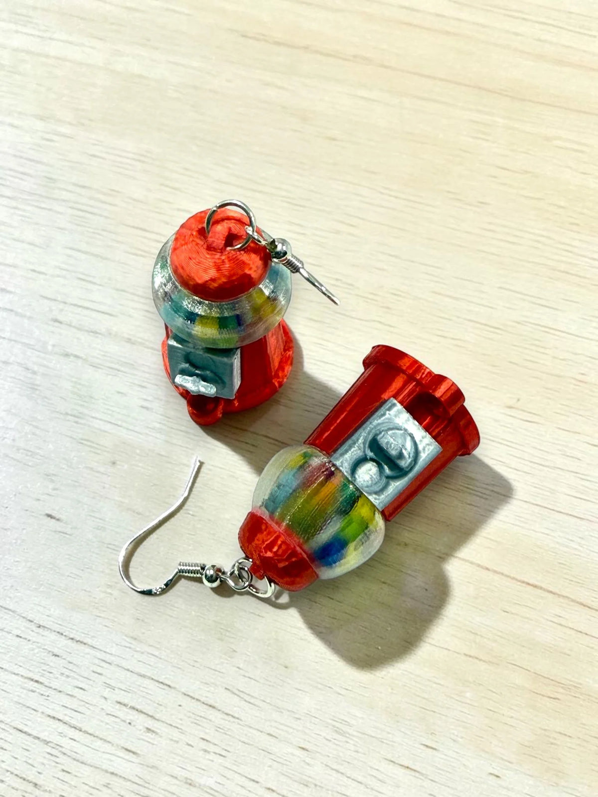Red gumball machine earrings shown from another angle
