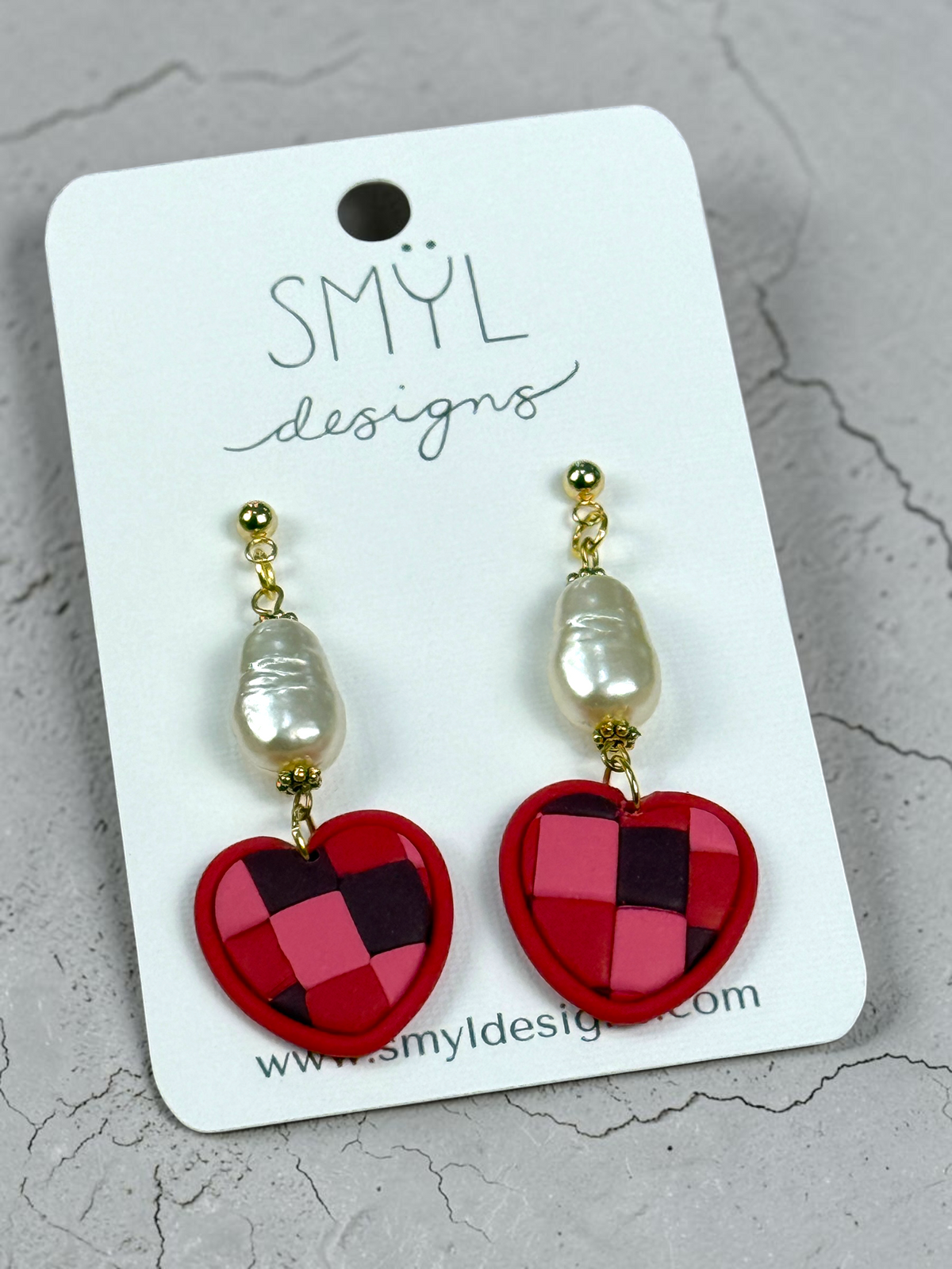Angled view of patchwork heart dangles with pearl accents