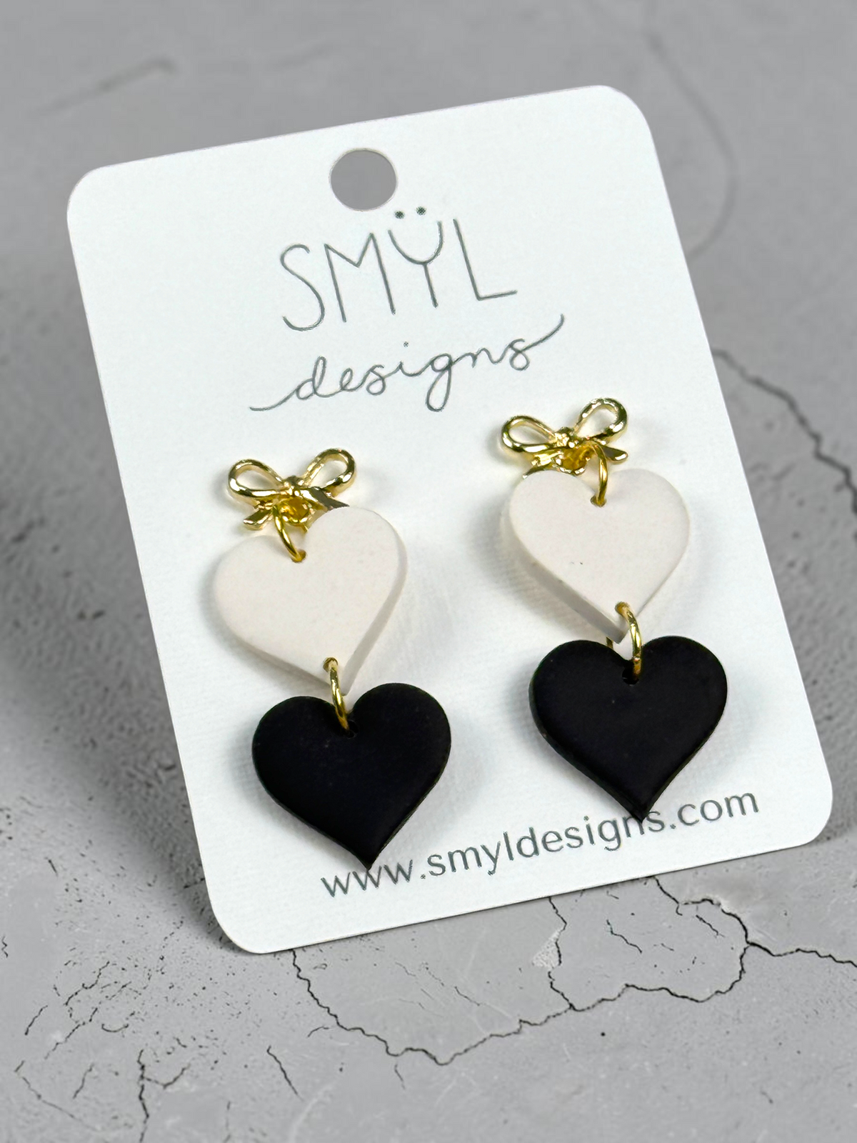 Black and white heart dangle earrings with gold bow studs
