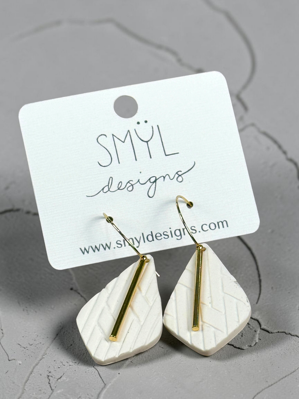 White textured teardrop hoop dangles with gold accent bars