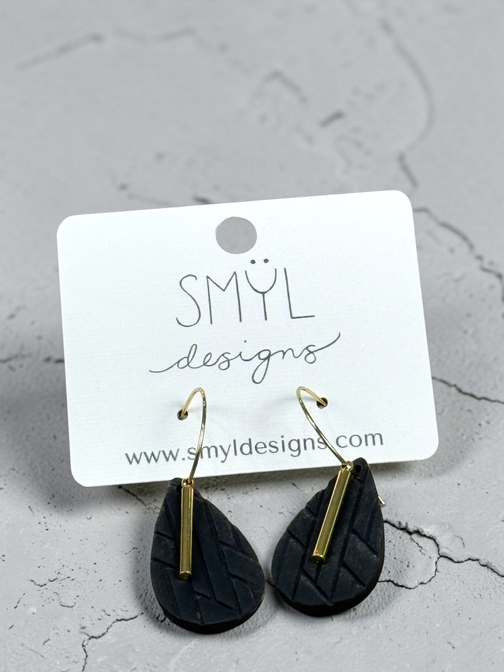 Black textured diamond hoop dangles with gold accent bars